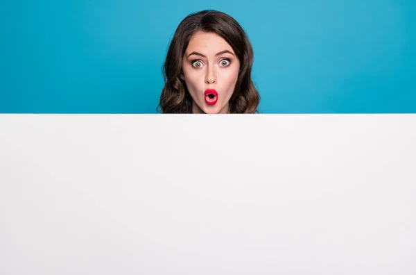 Lähikuva kuva melko hauska hullu nainen suu auki lukea tyhjä mainos banneri uutuus yllätys plakkarin järkyttynyt kasvojen ilme eristetty sininen väri tausta — kuvapankkivalokuva
