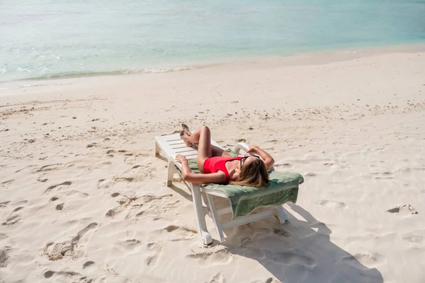 In voller Länge Foto der schönen Dame Liegestuhl azurblau Wasser exotischen Ort leer Wüstenstrand Sonnenbaden tragen Sonnenbrille roten Body genießen Sonnenstrahlen Ozean draußen — Stockfoto