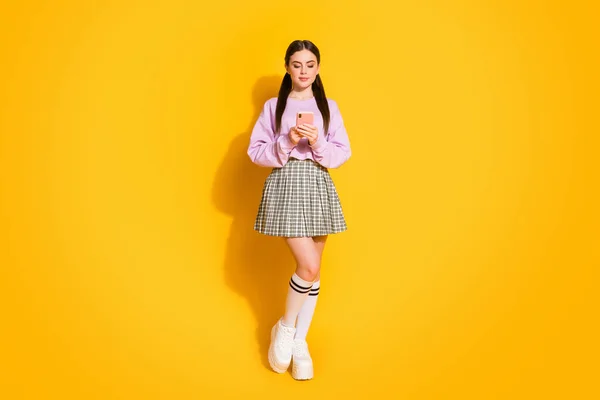 Teljes méretű fotó koncentrált blogger lány használ mobiltelefon olvasni a közösségi média információ Hozzászólás kopás jumper ruhák elszigetelt felett fényes fény színes háttér — Stock Fotó