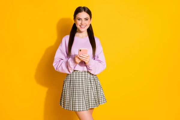 Portret van positieve vrolijke meisje gebruik smartphone genieten van chatten op social media netwerk slijtage geruite kleding geïsoleerd over heldere glans kleur achtergrond — Stockfoto