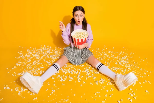 Top above high angle view full length photo of astonished girl watch horror series impressed pop corn lying on floor wear checkered jumper isolated over shine color background — Stock Photo, Image