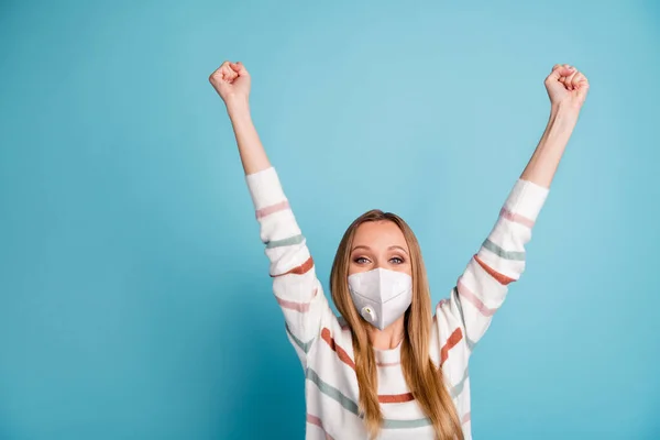 Retrato dela ela agradável atraente menina vestindo máscara de segurança levantando as mãos para cima celebrando agarramento mers cov influenza pneumonia síndrome recuperação isolado brilhante brilhante brilho vibrante azul cor fundo — Fotografia de Stock