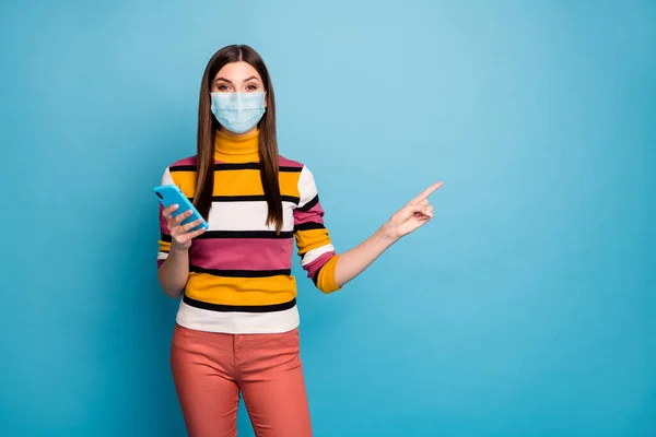 Retrato dela ela muito conteúdo menina vestindo máscara de gaze de segurança usando dispositivo demonstrando espaço de cópia pneumonia viral prevenção da gripe isolado brilhante fundo de cor azul vívido — Fotografia de Stock