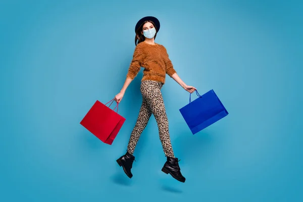 Full length body size άποψη της αυτή ελκυστική κοπέλα φορώντας μάσκα ασφαλείας άλμα πηγαίνει για ψώνια επισκεφθείτε το εμπορικό κέντρο boutique mers cov παράδοση πρόληψη απομονώνονται σε φωτεινό ζωντανό μπλε χρώμα φόντο — Φωτογραφία Αρχείου
