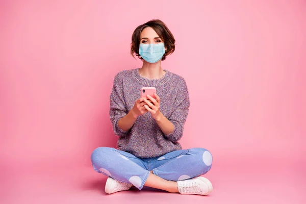 Retrato dela ela menina bonita agradável vestindo máscara de gaze usando dispositivo de busca de gripe agarramento mers cov influenza infecção preventiva doença pandemia notícias isoladas sobre cor pastel rosa fundo — Fotografia de Stock