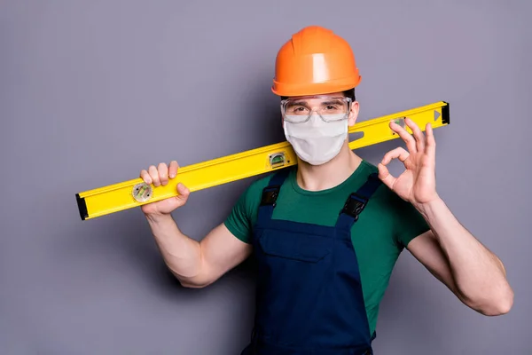 Close-up portret van zijn hij aantrekkelijke gezonde man werkman dragen veiligheidsgaas masker bril stoppen besmetting mers cov infectie dragen hulpmiddel tonen ok-teken geïsoleerde grijze kleur achtergrond — Stockfoto