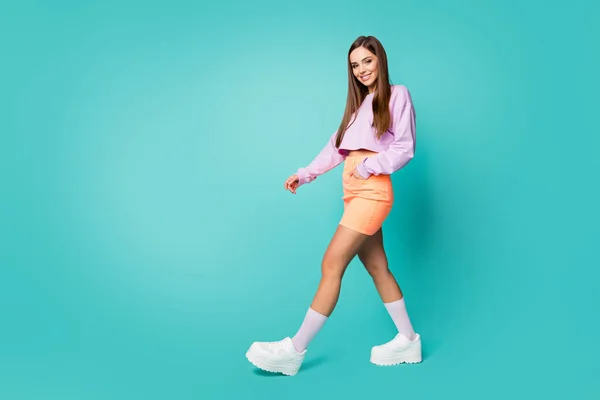 In voller Länge Profilfoto von funky cool Dame Jugend Outfit Kleidung zu Fuß auf der Straße tragen Trend lila abgeschnittenen Pullover nackten Bauch orange Rock Schuhe Socken isoliert teal Farbe Hintergrund — Stockfoto