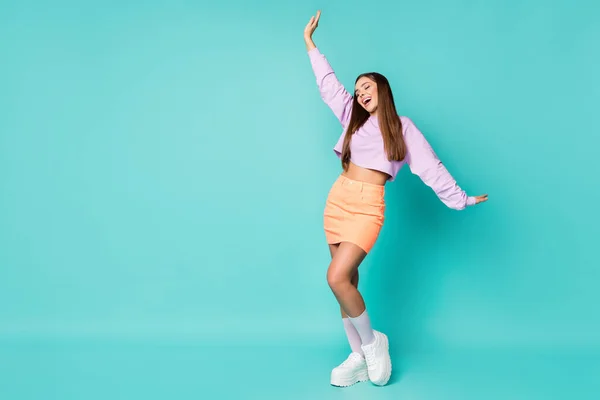 Foto de tamaño completo de la señora divertida sostienen los brazos levantados en el aire de buen humor día soleado desgaste púrpura suéter recortado vientre desnudo falda naranja zapatos blancos calcetines color verde azulado aislado fondo — Foto de Stock