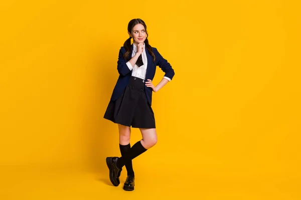 Foto de adolescente adolescente pensando en el nuevo año escolar usando negro no firme aislado sobre amarillo brillante color de fondo —  Fotos de Stock