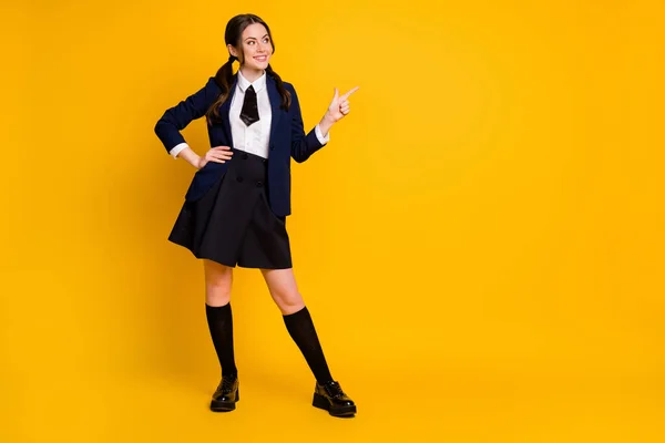 Full length body size view of her she nice attractive pretty glad cheerful cheery schoolgirl demonstrating copy space select advert ad isolated on bright vivid shine vibrant yellow color background — Stock Photo, Image