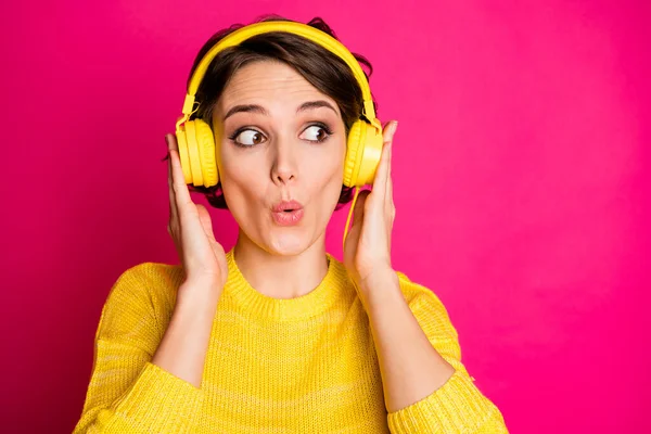 Portret van verbaasd grappig gek meisje hebben gele headset luisteren ongelooflijke muziek onder de indruk kijken copyspace slijtage jumper geïsoleerd over heldere kleur achtergrond — Stockfoto