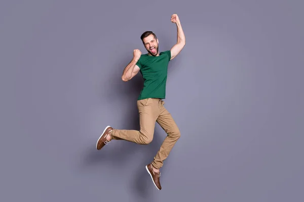 Full längd foto av glada funky lycklig kille hoppa fira coronavirus seger lotteri höja nävar skrika ja bära bra utseende kläder skor isolerad över grå färg bakgrund — Stockfoto