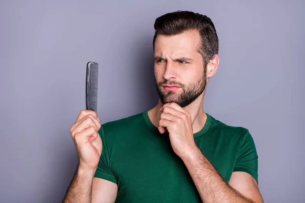 Porträtt av sinnade pensiv kille ser kam känsla omedveten om hårvård förfarande bära grön t-shirt isolerad över grå färg bakgrund — Stockfoto