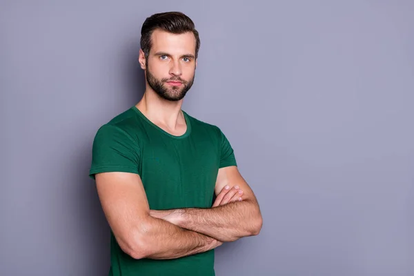 Φωτογραφία του ελκυστικού άντρα επιχειρηματίας αφεντικό εργαζόμενος τακτοποιημένο χτένισμα μπράτσα σταυρωμένα δεν χαμογελά αυτοπεποίθηση πρόσωπο φορούν casual πράσινο t-shirt απομονωμένο γκρι χρώμα φόντο — Φωτογραφία Αρχείου