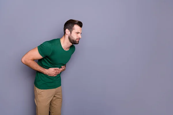 Foto de perfil lateral del hombre frustrado tocar las manos estómago sufren dolor vómito copyspace usar pantalones aislados sobre fondo de color gris — Foto de Stock