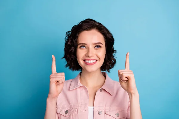 Closeup photo of attractive lady short black hairstyle good mood direct fingers up empty space advising novelty shopping online wear casual pink denim jacket isolated blue color background — Stock Photo, Image