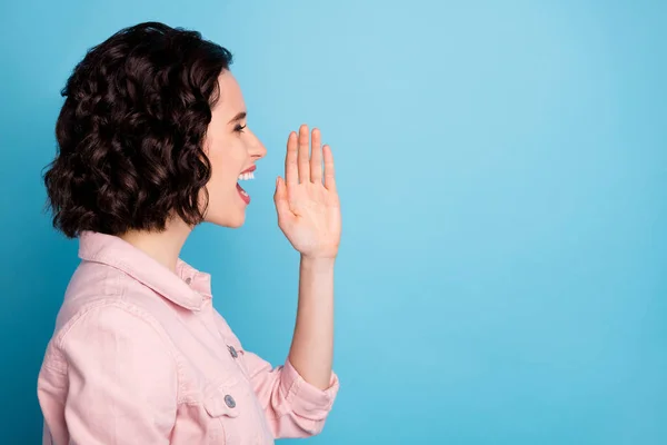 Primer plano foto de perfil de señora atractiva peinado corto mirar lado vacío espacio brazo cerca de la boca gritando corona virus información desgaste casual chaqueta de mezclilla rosa aislado fondo de color azul — Foto de Stock