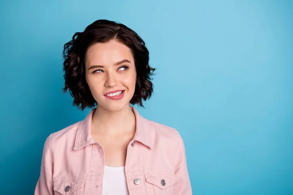 Foto de primer plano de atractiva señora interesada arreglado pelo negro corto mirar lado espacio vacío morder labios se preguntaba desgaste chaqueta de mezclilla rosa casual aislado fondo de color azul — Foto de Stock