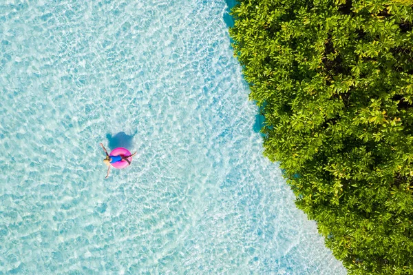 Yüksek açılı, havadan drone görüntüsü. Okyanusta kauçuk halkada yüzen çekici kız. Saf su rüya oteli hafta sonu. — Stok fotoğraf