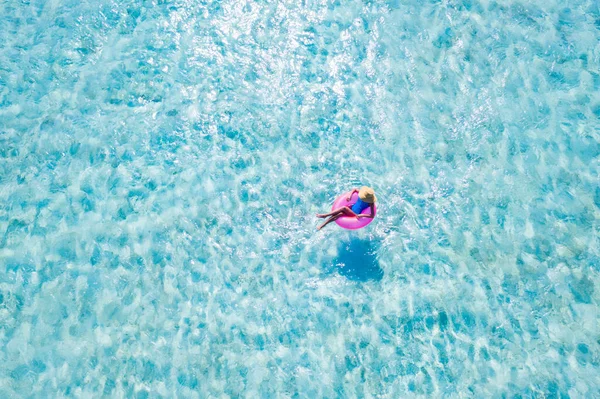 Yüksek açılı hava aracının üstünde ince, çekici bir kız saf deniz suyu rüya turunda yüzüyor güneşli, güneşli bir günün keyfini çıkarıyor. — Stok fotoğraf