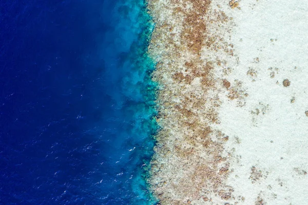 Cropped top acima alto ângulo aéreo drone vista de puro azul oceano água lavagem litoral pedras recife de coral selvagem luxuoso destino tour venda quente reserva antecipada indonesia vietnam — Fotografia de Stock