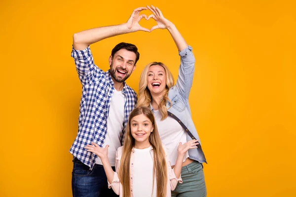 Foto mooi mam dame knap vader klein school meisje dochter tonen gelukkig ouders vieren verjaardag maken hart figuur dragen casual kleding geïsoleerd geel kleur achtergrond — Stockfoto