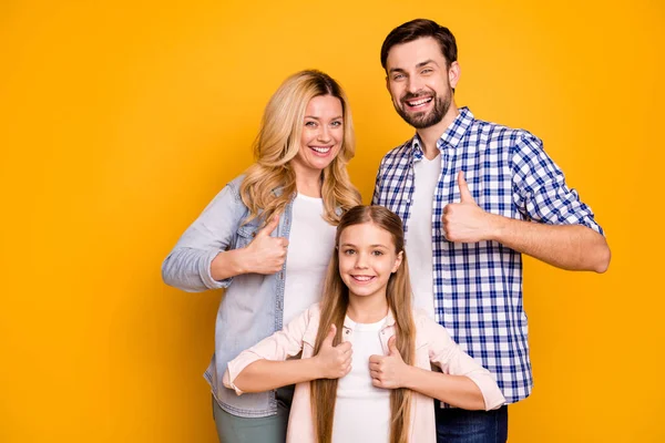 Foto Frau schöne Mutter Dame schöner Mann Papa Kerl paar kleine Schulmädchen Tochter glücklich zusammen heben Daumen nach oben tragen lässige Kleidung isoliert gelbe Farbe Hintergrund — Stockfoto