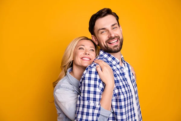 Foto hermosa esposa dama guapo marido chico pareja abrazo su fuerte espalda sentir seguridad buen humor en el amor perfecto par celebrar brazos usar casual camisas ropa aislado amarillo color fondo — Foto de Stock