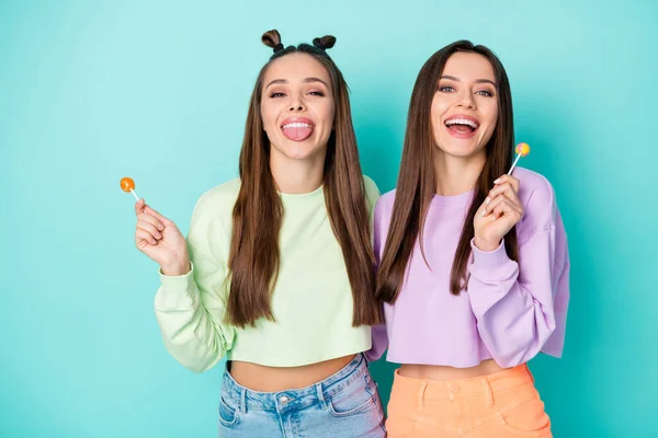 2 명의 웃긴 여성이 롤리팝 추 파 사탕을 들고 있는 사진, 중독 된 혀를 내밀어 입을 벌리고 있는 달콤 한 여성들의 모습 — 스톡 사진