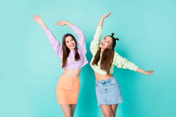 Portrait of nice-looking attractive lovely pretty charming slim fit cheerful cheery brown-haired girls dancing having fun isolated over bright vivid shine vibrant blue green color background — Stock Photo, Image