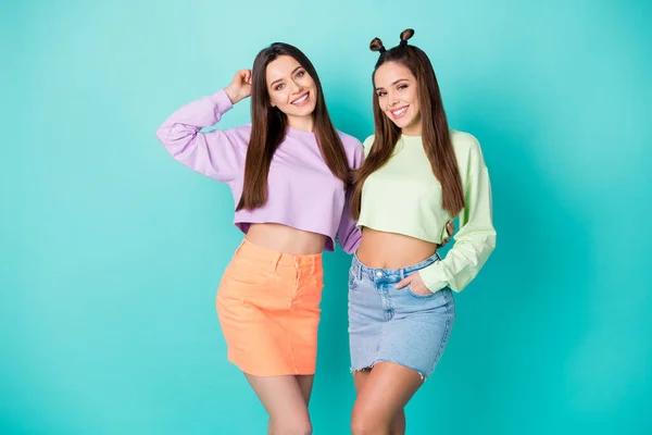 Foto de cool duas namoradas bonita senhora cool juventude olhar roupas abraçando bom humor desgaste camisolas cortadas barriga nua saias curtas isolado pastel teal cor fundo — Fotografia de Stock