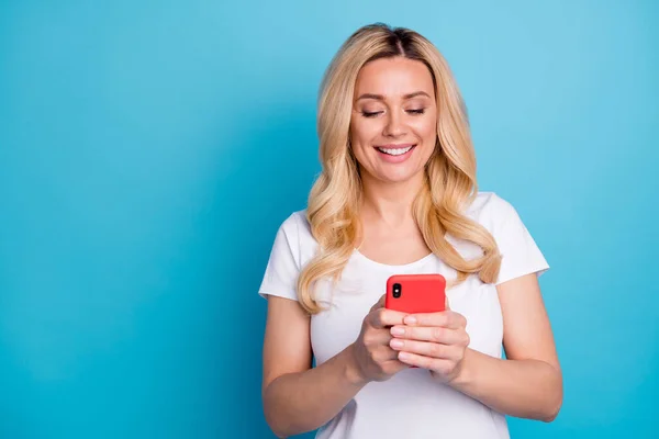 Portrait of positive cheerful woman use smartphone read social network information check account wear trendy clothes isolated over blue color background — Stock Photo, Image