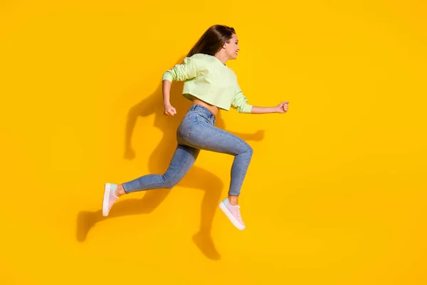 Full size profile side photo of cheerful girl jump run fast speed hurry season discounts wear good look clothes gumshoes isolated over shine color background — Stock Photo, Image