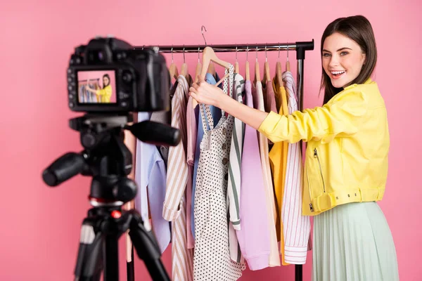 Photo of pretty lady broadcast professional camera online blog new episode showing fashion collection feedback wear yellow leather jacket skirt isolated pastel pink color background