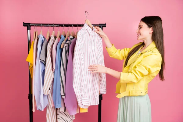 Profil zdjęcie dość wesoły lady zegarek salon mody kolekcja wybierając ubrania trzymać koszulę nosić trend żółty skórzana kurtka spódnica odizolowany pastelowy różowy kolor tło — Zdjęcie stockowe