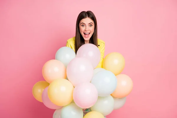 Foto av rolig charmig dam hålla händer många luft ballonger festliga händelse födelsedag fest öppen mun slitage trend gult läder jacka isolerad pastell rosa färg bakgrund — Stockfoto