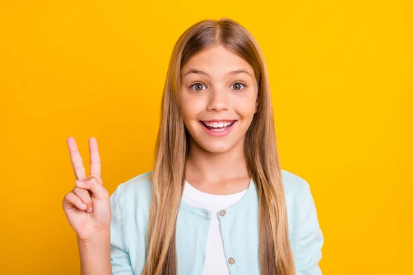 Closeup foto do belo pequeno loiro senhora segurar braço mostrando símbolo v-sinal dizer oi amigos bom humor desgaste casual azul camisa isolado amarelo brilhante cor de fundo — Fotografia de Stock