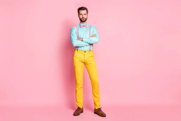 Full size photo of handsome guy trend stylish look red carpet celebrity arms crossed photographing wear shirt suspenders bow tie yellow pants footwear isolated pastel pink color background — Stock Photo, Image