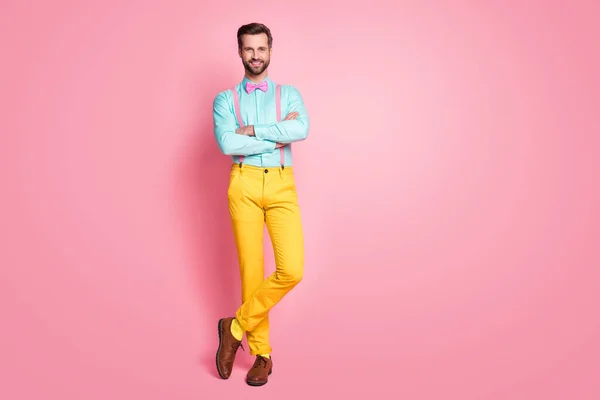 Foto de cuerpo entero de chico guapo tendencia ropa alfombra roja celebridad brazos cruzados fotografiando posando desgaste camisa tirantes lazo de lazo pantalones amarillos zapatos aislados pastel rosa color fondo — Foto de Stock