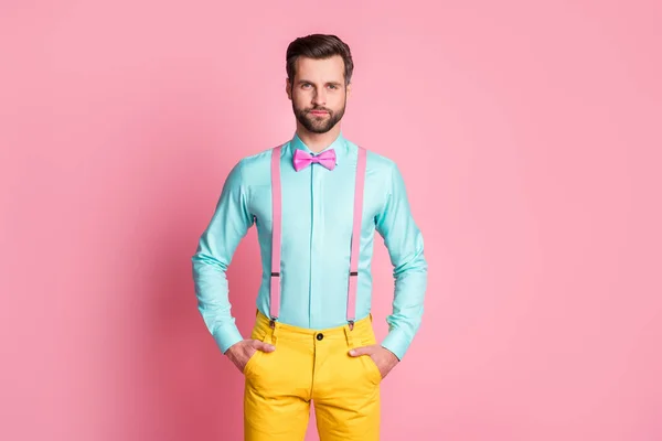 Foto de cara macho bonito tendência roupas braços bolsos auto-confiante pessoa trabalhador desgaste teal camisa suspensórios arco gravata amarelo calças isoladas pastel cor rosa fundo — Fotografia de Stock