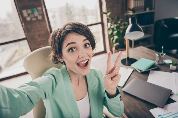 Positive girl broker promoter blogger influencer make selfie enjoy startup development strategy progress workshop training seminar show v-sign sit armchair in workstation sul posto di lavoro — Foto Stock