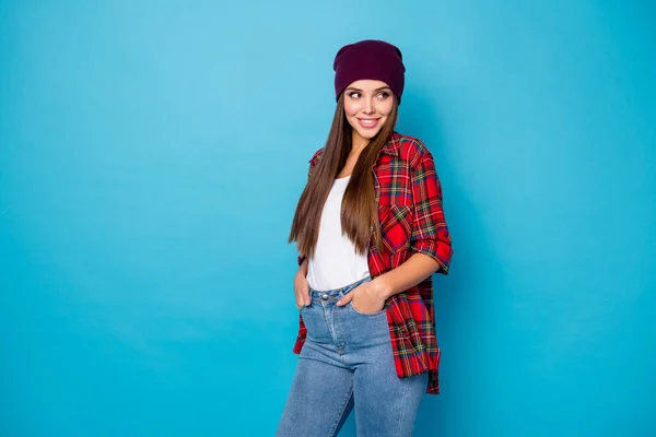 Foto di cool elegante buon umore signora contento caldo primavera tempo strada vestiti sembrano interessati lato vuoto spazio indossare casual cappello plaid camicia jeans isolato blu colore sfondo — Foto Stock