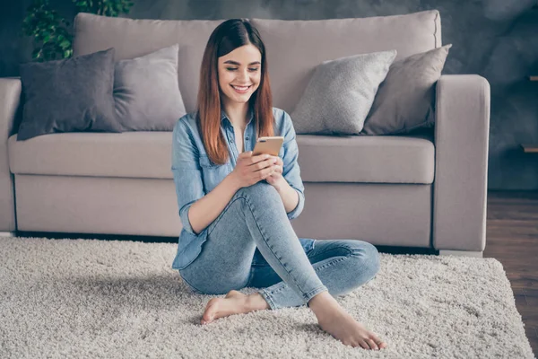 Full length foto di positivo allegro ragazza studente sedersi tappeto pavimento uso smartphone hanno comunicazione di social media con seguaci abbonati in casa al chiuso — Foto Stock