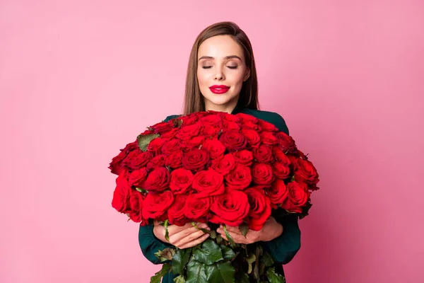 可愛い女性の写真は大きな赤い長いバラの花束のボーイフレンドの誕生日プレゼント驚きは快適な匂いが緑のドレスを着用孤立パステルピンク色の背景を保持 — ストック写真