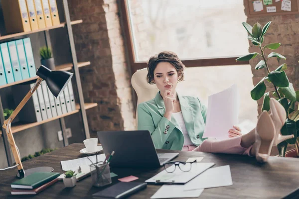 Foto de atractivo atento jefe de negocios señora portátil mesa distancia casa trabajo remoto celebrar documentos leer contrato ver pantalla piernas mesa confidente jefe sentarse silla moderna oficina interior — Foto de Stock