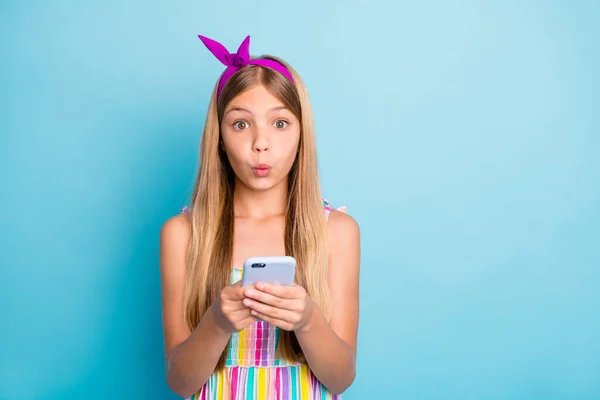 Portrait of astonished kid girl use smartphone impressed social network information wear dress skirt isolated over blue color background — Stock Photo, Image