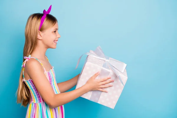 Προφίλ πλευρά φωτογραφία του θετικού χαρούμενο κορίτσι παιδί κατέχουν μεγάλη διάστικτη συσκευασία δώρου δώσει ο καλύτερος φίλος της για την επέτειο κόμμα γιορτή φορούν καλά ρούχα εμφάνιση απομονωμένο μπλε χρώμα φόντο — Φωτογραφία Αρχείου