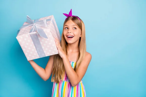 긍정적 이고 명랑 한 여자 아이가 결혼기념일에 받을 수있는 큰 선물 상자를 들고 있는 모습이 무엇인지 알고 싶어 한다. — 스톡 사진