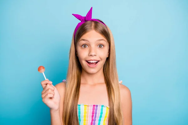 Close-up retrato dela ela agradável atraente encantador bonito bonito bonito alegre menina de cabelos longos comendo doces de caramelo isolado no brilhante brilho vívido vibrante azul cor de fundo — Fotografia de Stock