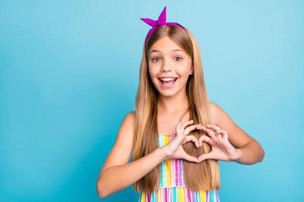 Portrét ohromený energický veselý dítě dívka, aby srdce tvar prst demonstroval Amor láska symbol hrudník nosit módní oblečení izolované přes modré barvy pozadí — Stock fotografie
